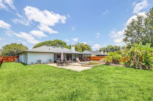a house with a yard with a grassy yard at Tranquil Oasis 4BR Pool Home in Orlando