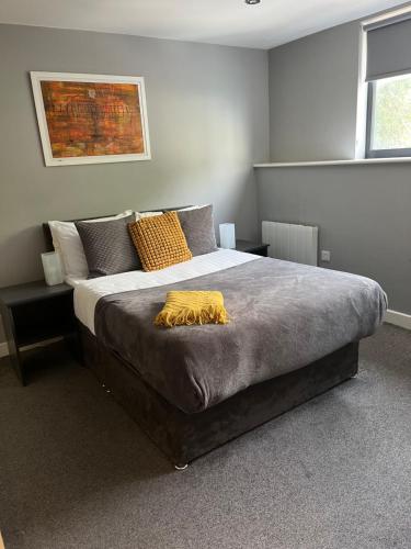 a bedroom with a large bed with a yellow blanket on it at Two bedroom Newcastle City Quayside Apartment in Newcastle upon Tyne