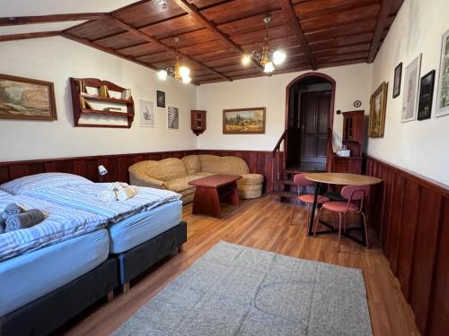 a bedroom with a bed and a couch and a table at Penzión Grand, Self Check-In, free private parking in Banská Bystrica