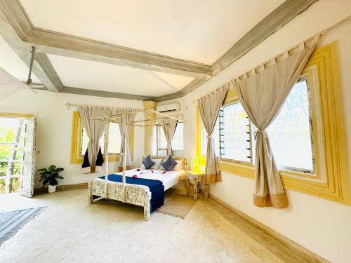 a bedroom with a bed in a room with windows at Dream Luxury B&b Watamu in Watamu