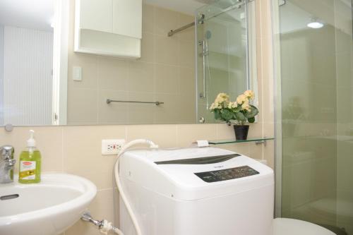 Un baño con inodoro, lavabo y ducha. en Le Monaco Suites - Azure North Pampanga, en San Agustin