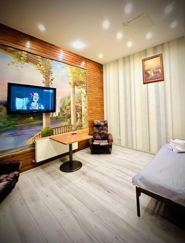 a living room with a tv and a table and a chair at Готельно-ресторанний комплекс Б-52 in Kyiv