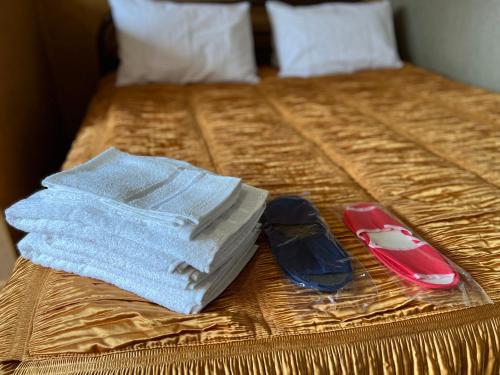 a bed with a book and a cell phone on it at Готельно-ресторанний комплекс Б-52 in Kyiv