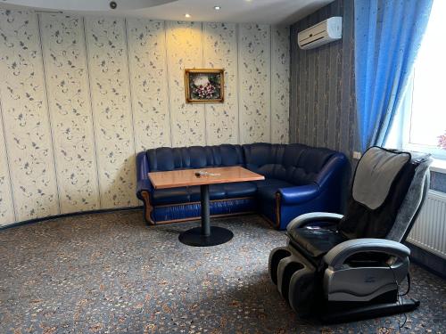 a living room with a blue couch and a table at Готельно-ресторанний комплекс Б-52 in Kyiv