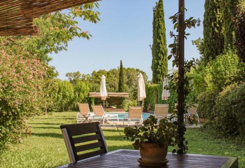 a table with chairs and umbrellas in a garden at La Lolita ( Adults Only ) in Sant Mart&iacute; Vell