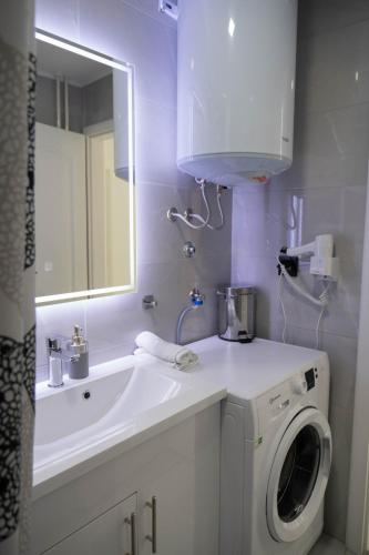 a bathroom with a sink and a washing machine at Spa intimo Višegrad in Višegrad