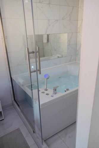 a white bathroom with a tub and a shower at Spa intimo Višegrad in Višegrad