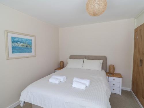 a bedroom with a white bed with two towels on it at 16 Church Street in Lyme Regis