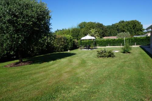 a large yard with a gazebo in the grass at Les Chambres de PEYROUTOUS in Pont-du-Casse