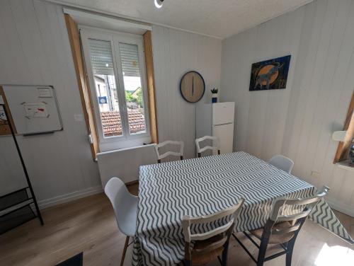 a dining room with a table and chairs and a window at Charmant duplex 100m2 in Mouchard