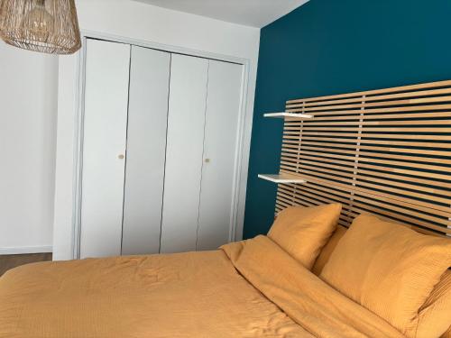 une chambre avec un lit et un mur bleu dans l'établissement Appartement intra-muros Avignon, à Avignon