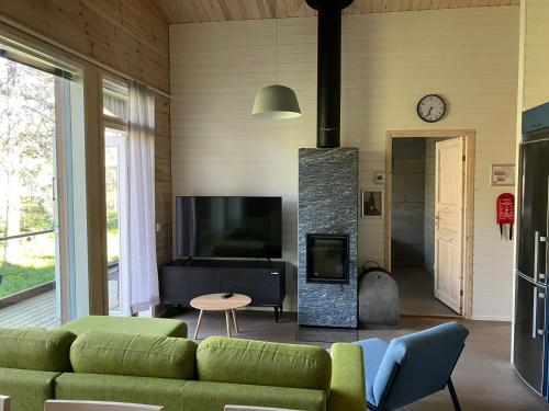 a living room with a green couch and a fireplace at Villa Fox Ruka in Ruka