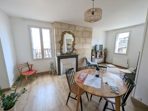 salon ze stołem i kominkiem w obiekcie Cocon lumineux sous les toits de Bordeaux w mieście Bordeaux