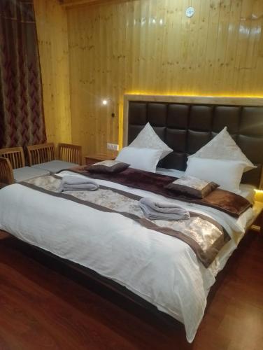a large bed with white sheets and pillows at Nubra house diskit in Leh
