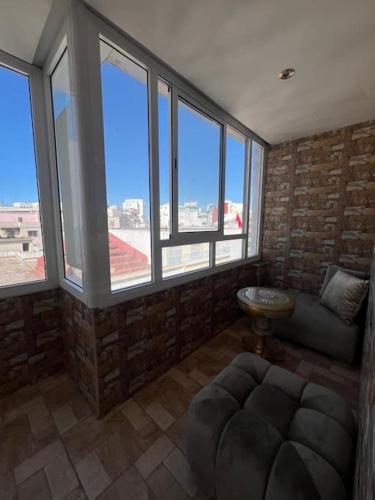 a living room with large windows and a couch at Appartement RITZ in Tangier