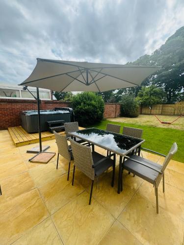 a table and chairs with an umbrella on a patio at The Crescent in Great Yarmouth