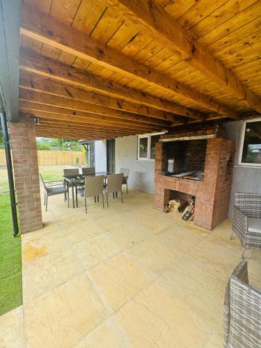 a patio with a fireplace and a table and chairs at The Crescent in Great Yarmouth
