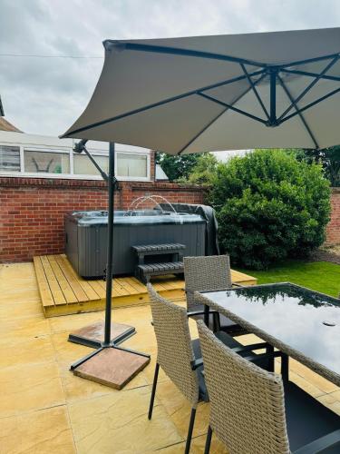 a patio with a table and an umbrella at The Crescent in Great Yarmouth