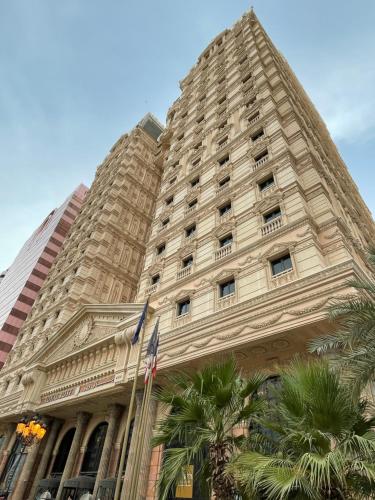 a tall building with palm trees in front of it at Royal Rose Abu Dhabi, a Curio Collection by Hilton Affiliated Hotel in Abu Dhabi