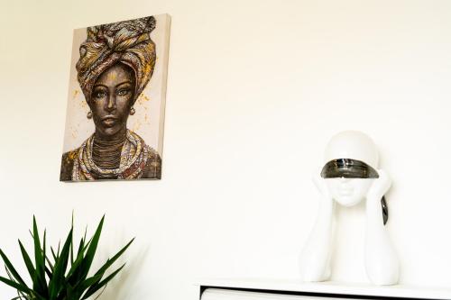a picture of a woman on a shelf next to a statue at Douillet 2 pièces proche de Paris et de Disneyland in Villemomble