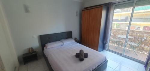 - un lit avec une croix dans une chambre dotée d'une fenêtre dans l'établissement au calme et 2 pas de la mer, à Nice