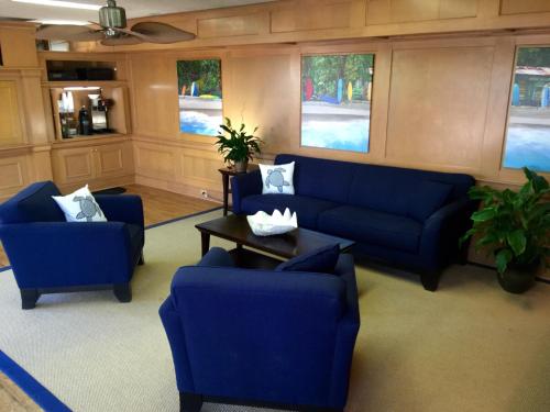 a living room with blue couches and a table at Coral Sands Inn in Ormond Beach