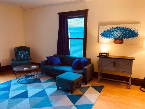 a living room with a blue couch and a table at Treetop Apartment in the Heart of MPLS in Minneapolis