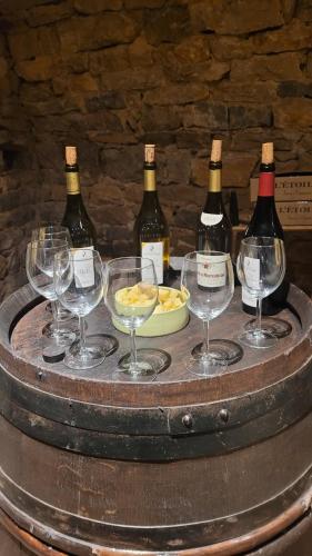 un groupe de bouteilles de vin et de verres sur un fût dans l'établissement Au lavoir du Serein 