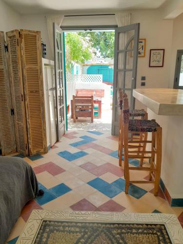 a living room with a tile floor and a kitchen at Vent Des Dunes in Essaouira