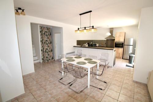 une cuisine et une salle à manger avec une table et des chaises dans l'établissement Bord de mer, villa 4 chambres, grand jardin, à Martigues