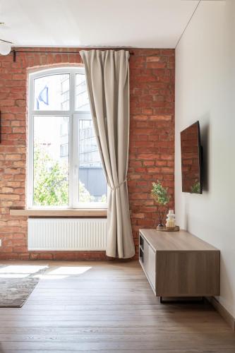 a living room with a brick wall and a window at Rossak apartment 1 in Panevėžys