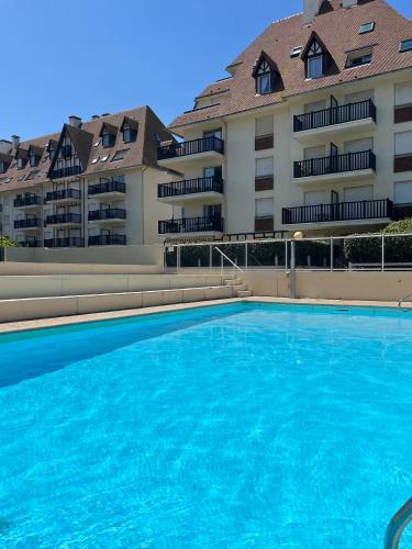 une grande piscine devant un immeuble dans l'établissement Studio cocooning petite vue mer, à Cabourg