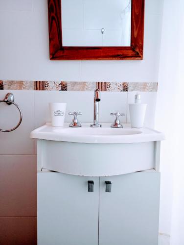 a bathroom with a white sink and a mirror at Tierra Adentro Colón in Colón