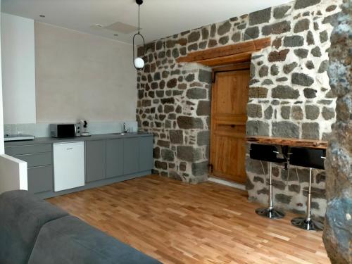 a kitchen with a stone wall and a table at Le relax max in Le Puy en Velay