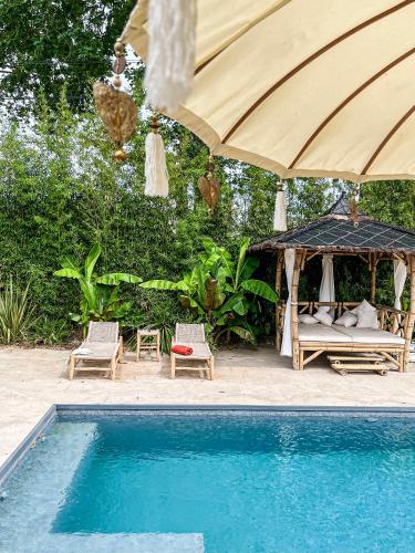 - une piscine avec un kiosque, un lit et un parasol dans l'établissement Charmante villa avec piscine chauffée, proximité des plages, à Vias