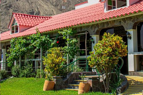 a house with a red roof with trees in the yard at Villasol Hotel in Lunahuaná