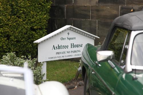 a sign for an office house with a green car at Ashtree House Hotel, Glasgow Airport & Paisley in Paisley