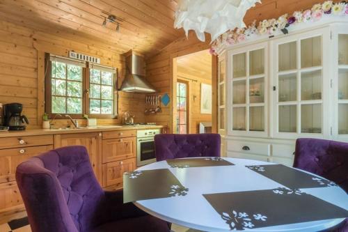 a kitchen with a table and purple chairs at Fantastisch chalet met veel ruimte en fijne tuin in Epe