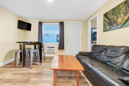 a living room with a leather couch and a table at Abellona Inn & Suites in Old Orchard Beach