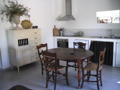 a kitchen with a wooden table and chairs at "Le Vent d'Étoile" B&B and Guesthouses in Mormoiron
