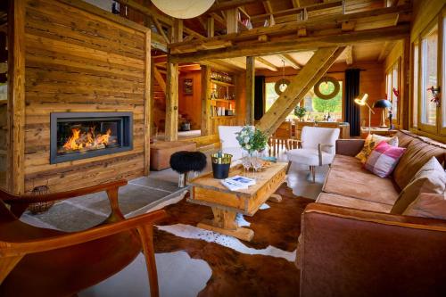 a living room with a fireplace in a log house at Chalet La Chandelle - OVO Network in Bionnassay