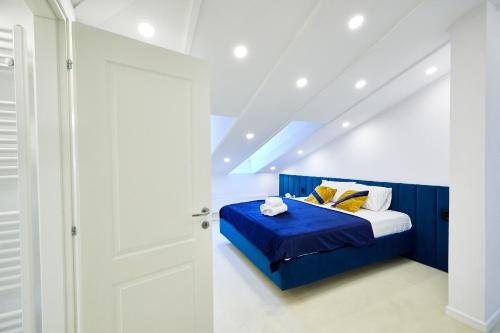 a bedroom with a blue bed with yellow pillows at Carol Park View in Bucharest
