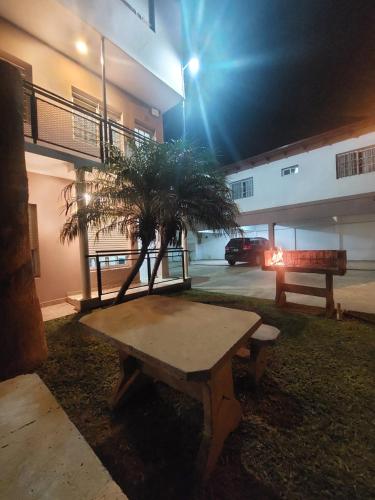Una mesa de picnic con un árbol frente a un edificio. en El amanecer de Colon, en Colón