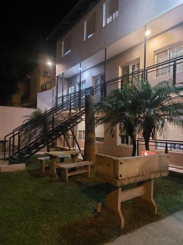 un edificio con una mesa y bancos delante en El amanecer de Colon, en Colón