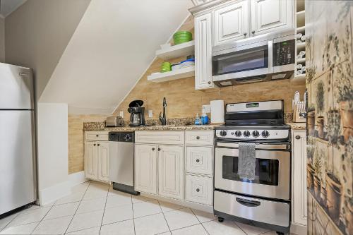 a kitchen with white cabinets and stainless steel appliances at Villa Mulvey #1 in St. Augustine