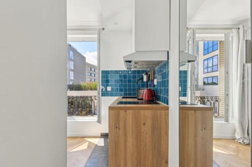 Il comprend une cuisine équipée d'une cuisinière. four supérieur à côté d'une fenêtre dans l'établissement Studio cosy aux portes de Paris, à Montrouge