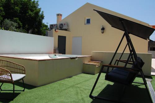 a patio with a chair and an umbrella on a roof at THE ORANGE TREE HOUSES - vista Pátio by Live and Stay in Abrantes