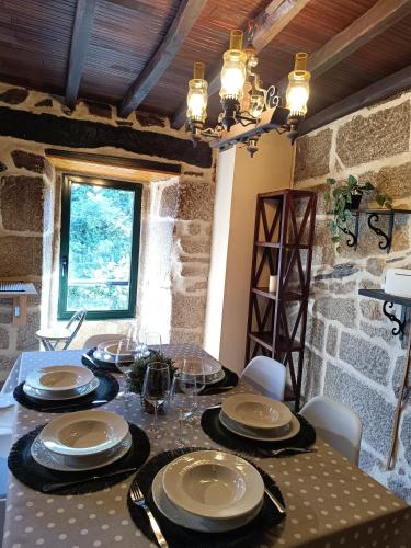 a dining room with a table with plates and glasses at Luz do Sil in Ourense