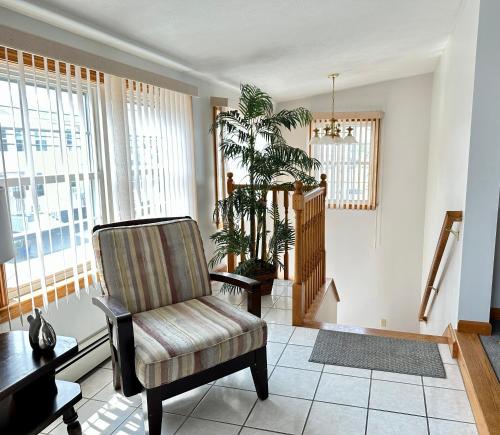 a living room with a chair and a plant at Abellona Inn & Suites in Old Orchard Beach
