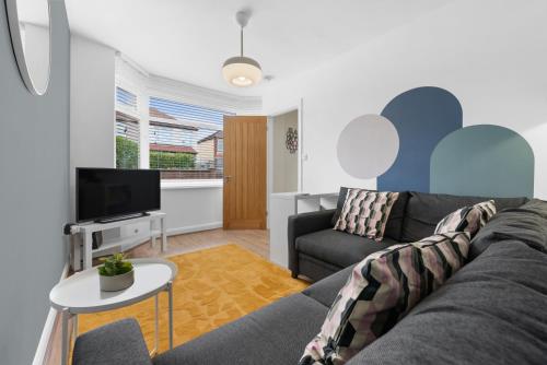 a living room with a couch and a tv at 3BR nr Warwick Uni-Free Parking, Fast WiFi, Sleeps 6 in Canley